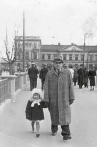 Ar audžutēvu Edgaru Hermanoviču. Pastaigā Rīgā 1941. gadā. «Vairiņa ir pazaudējusi savus cimdus, un paps viņai aizdevis savējos, lai nesaltu rokas,» komentē pati Vaira. Īsto tēvu Vaira nekad savā mūžā nesatika, jo viņš 1938. gada janvārī gāja bojā vētrā uz kuģa Atlantijas okeānā, jaundzimušo meitu tā arī neredzējis. Foto no privātā arhīva