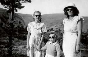 Marokā. Pie Dauratas spēkstacijas 1949. gada vasarā kopā ar mammu un brālīti Edvīnu. «Mātei un meitai mugurā ar roku šūtas katūna kleitas, kurām audums pirkts vietējā iksestdienas lauku tirdziņā.» Ģimene no bēgļu nometnes Vācijā 1949. gada aprīlī nonāca franču Marokā un nodzīvoja tur piecus gadus, līdz 1954. gadā izdevās pārcelties uz Kanādu. Foto no privātā arhīva