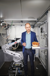 «Ar vai bez mums pēc gadiem sešiem vai septiņiem šādi roboti būs visur. Tas būs standarts,» jau pirms trim gadiem teica Konstantīns Korčjomkins no jaunuzņēmuma Roboeatz, kas Rīgā atklāja ēstuvi ar ēdienu gatavojošu roboroku