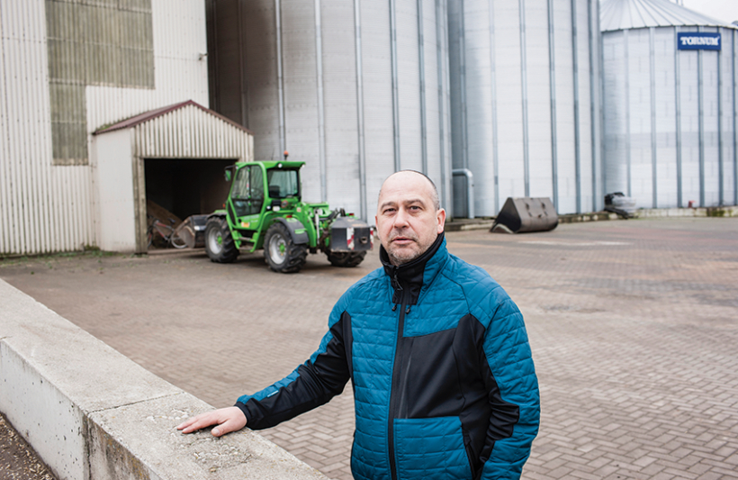 Zemnieku saeimas valdes priekšsēdētājs Juris Lazdiņš pie graudu pirmsapstrādes kompleksa. To pirms astoņiem gadiem uzbūvēja par 1,2 miljoniem eiro, kas iegūti no ES atbalsta naudas investīcijām lauksaimniecībā. Foto — Ieva Salmane