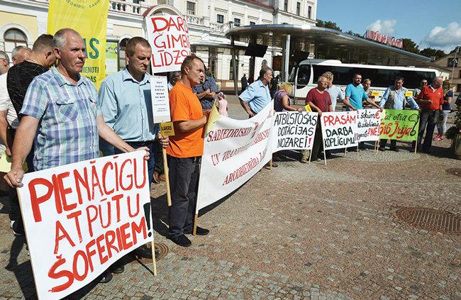 Šoferu pikets Liepājā 2018. gada augustā. Nākamā gada pavasarī viņi bija gatavi arī streikot, taču tiesa arodbiedrības pieteikumu atzina par nelikumīgu. Galvenās streika prasības bija lielāka alga un sabalansēts darba grafiks. Foto — Egons Zīverts