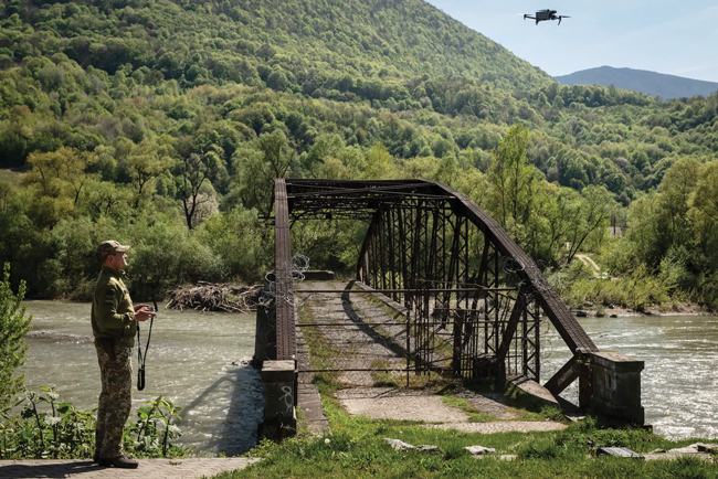 Ukraiņu robežsargs ar dronu pie robežupes Tisas, kuru daudzi vīrieši izmanto nelegālai izceļošanai uz ārvalstīm