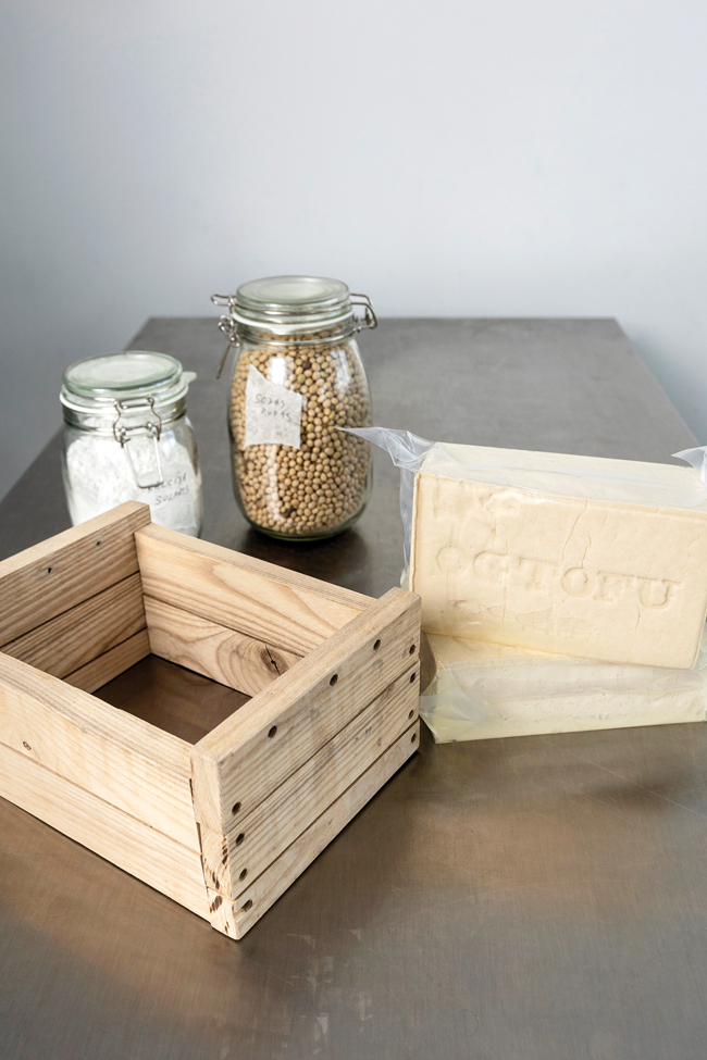 Tofu izejvielas — Latvijā audzētas sojas pupiņas un kalcija sulfāts —, Mārtiņa veidotā koka prese un gatavais produkts. Foto — Ieva Salmane