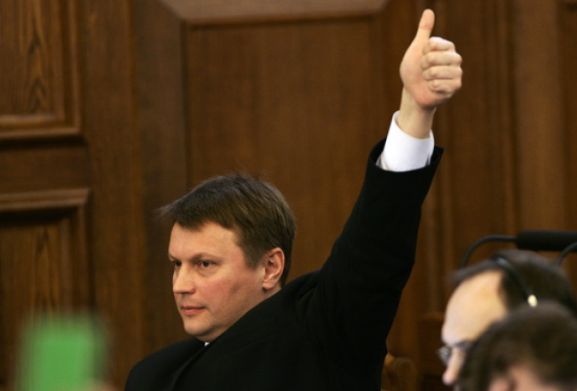 Saskaņas centra Saeimas frakcijas vadītājs Valērijs Agešins rāda zīmi, kā balsot frakcijai. Foto: Andrejs Strokins, F64