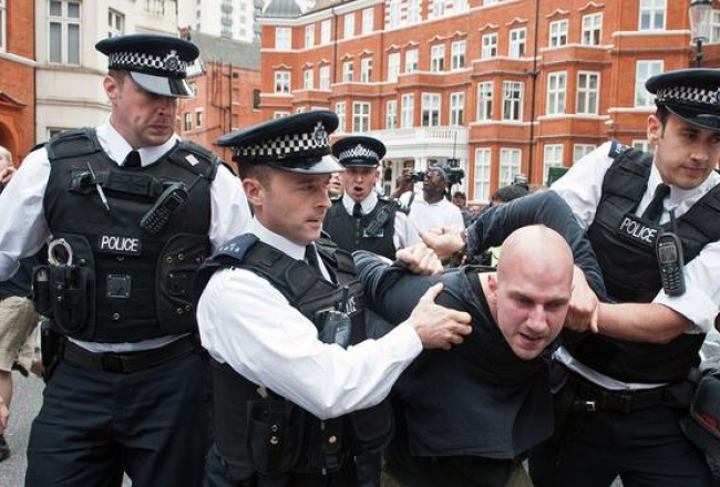 Britu policisti saņem ciet Asanža atbalstītāju. Foto: AFP/LETA