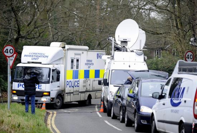 Britu policijas izmeklētāju busiņš un daudzo mediju automobiļi pie Borisa Berezovska mājas. Foto: EPA/LETA