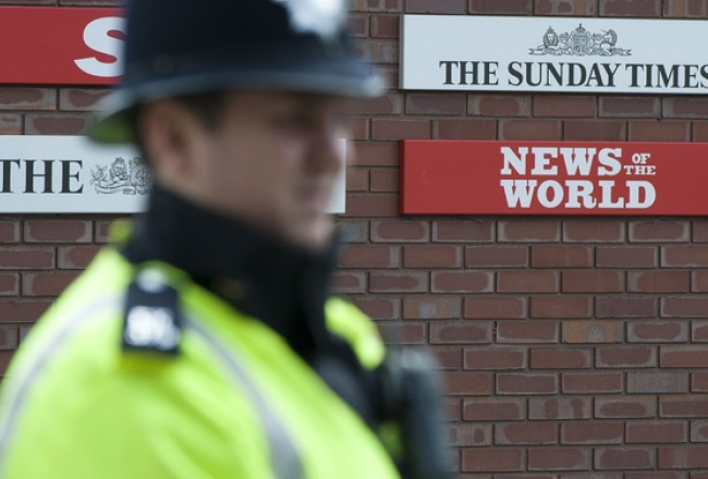 Britu policists apsargā skandalozo Mērdoka mediju redakcijas. Foto: AFP/LETA