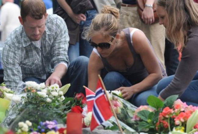 Cilvēki pie Oslo katedrāles noliek ziedus, pieminot piektdienas teroraktu upurus. Foto: EPA/LETA