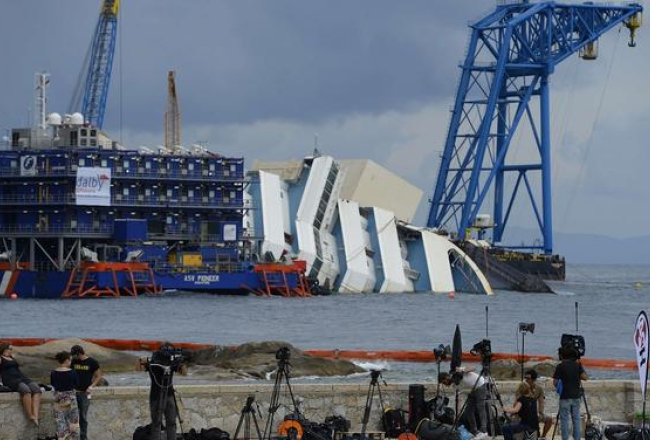 Žurnālisti jau svētdien ieņēmuši labākās vietas, lai fiksētu "Costa Concordia" izcelšanu. Foto: AFP/LETA