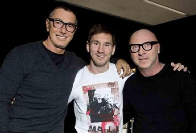 Itāļu modes mākslinieki Stefano Gabana (no kreisās) un Domeniko Dolče savā birojā Milānā šogad pozēja kopā ar "Barcelona" futbolkluba spēlētāju Laionelu Mesi. Foto: AFP/LETA