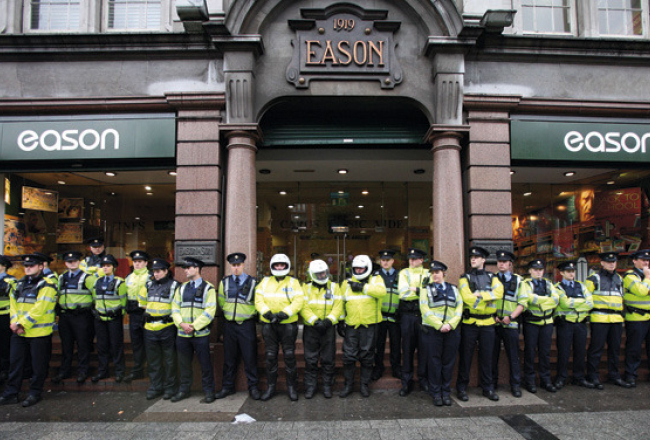 Policijas «mūris» pie grāmatnīcas Dublinā, kur 4.septembrī Tonijs Blērs ieradās uz prezentāciju un autogrāfu sniegšanu. Viņu sagaidīja aptuveni 200 protestētāji. Foto — AFP/LETA
