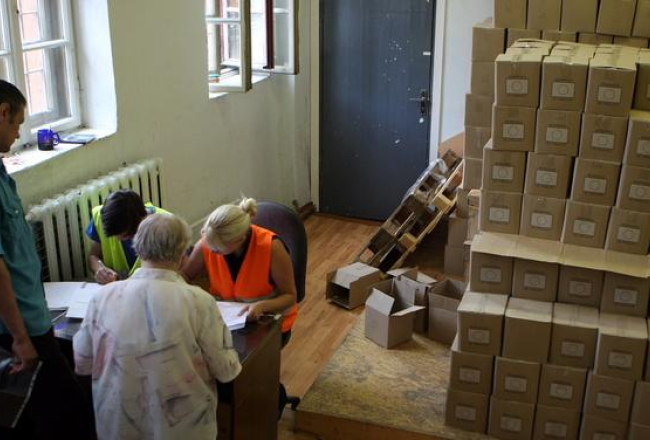 Cilvēki saņem pārtikas pakas trūcīgajiem biedrības "Latvijas Sarkanais Krusts" naktspatversmes telpās Gaiziņa ielā. Foto: Edijs Pālens, LETA