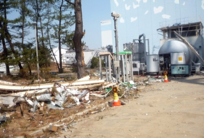 AES īpašnieka "Tokyo Electric Power" izplatīts attēls, kurā redzama avarējušā pirmā reaktora rietumu puse šī gada 13.aprīlī. 5.maijā reaktorā ienākuši pirmie strādnieki kopš postošās zemestrīces un cunami 11.martā. Avots: AFP/LETA