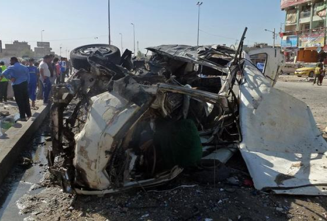 Automašīna Bagdādes ielās pēc bumbas eksplozijas. Foto: AFP/LETA