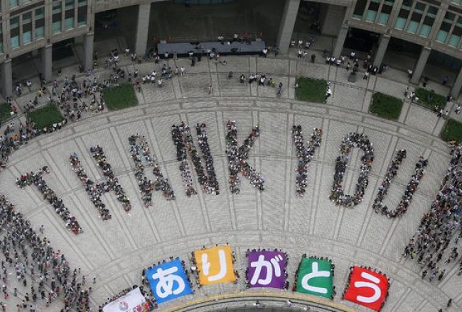 Japāņi pie Tokijas metropolitēna administratīvās ēkas izveidojuši uzrakstu "Paldies", tā pteicoties par 2020.gada olimpiādes vietas izvēli. Foto: AFP/LETA