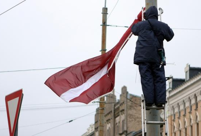 Uz valsts svētkiem arī pilsētas ielās tiek izlikti valsts karogi. Foto: Edijs Pālens, LETA