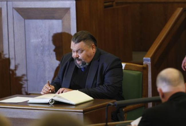 SC deputāts Valērijs Kravcovs paraksta 10.Saeimas deputāta svinīgo solījumu. Foto: Andrejs Strokins, F64