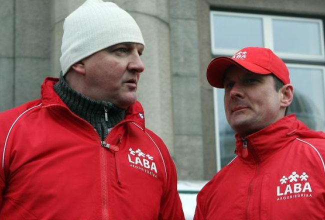 Arodbiedrības "LABA" priekšsēdētājs Raimonds Gailis (no labās) un arodbiedrības valdes priekšsēdētāja vietnieks Vladislavs Bartaševičs piedalās arodbiedrības "LABA" rīkotajā protesta akcijā par PVN likmes samazināšanu siltumapgādei. Foto: Edijs Pālens, LETA