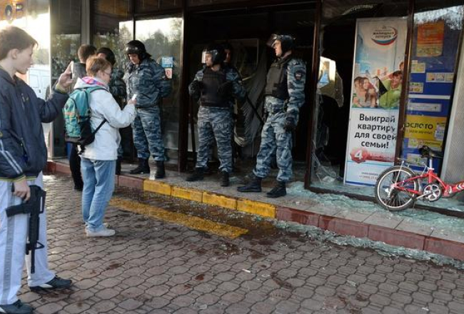 Krievijas policisti pie ieejas tirgotavā, kas jau ir izdemolēta. Foto: AFP/LETA
