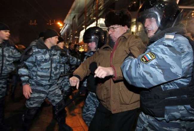 Miliči 15.decembrī aiztur cilvēkus pie Kijevas stacijas Maskavā, lai nepieļautu grautiņu izcelšanos. Foto: AFP/LETA