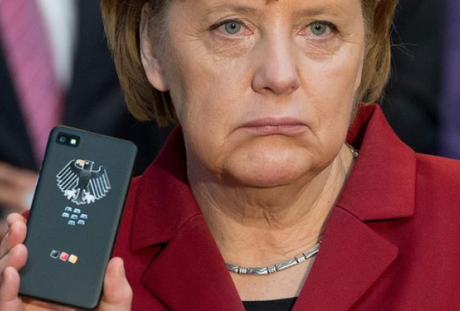 Vācijas kanclere Angela Merkele rāda savu telefonu. Foto: EPA/LETA