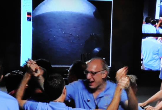 NASA lidojumu centra kontrolieri līksmo par pašgājēja robota veiksmīgo piezemēšanos uz Marsa. Foto: AFP/LETA