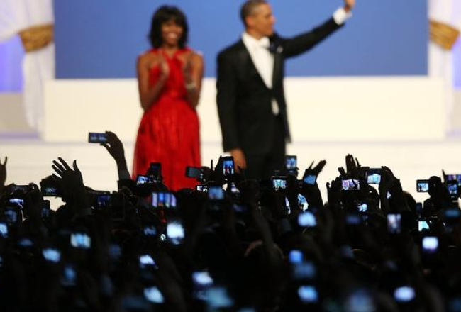 Mišela un Baraks Obama inaugurācijas ballē. Tūkstošiem roku ar mobilajiem telefoniem fotografē. Foto: AFP/LETA
