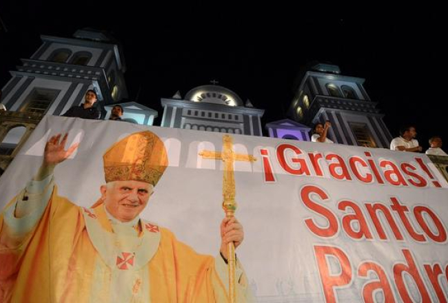 Ticīgie plakātā pateicas pāvestam Benediktam XVI. Foto: AFP/LETA