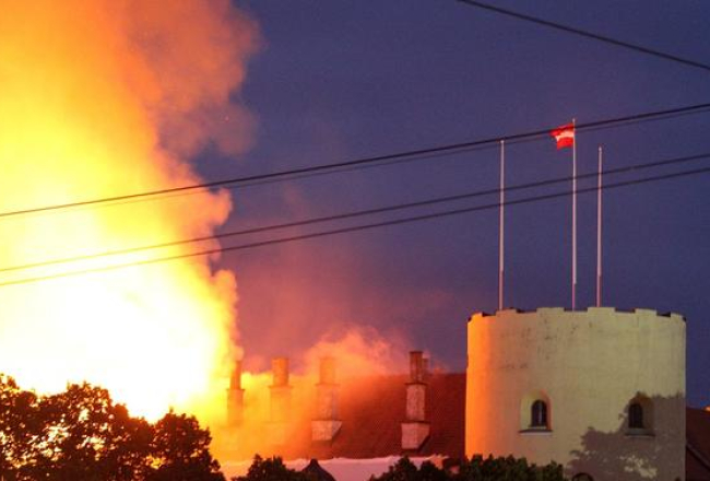 Degošā Rīgas pils. Tornī joprojām it simboliski plīvo valsts karogs. Foto: Egons Ansbergs, F64