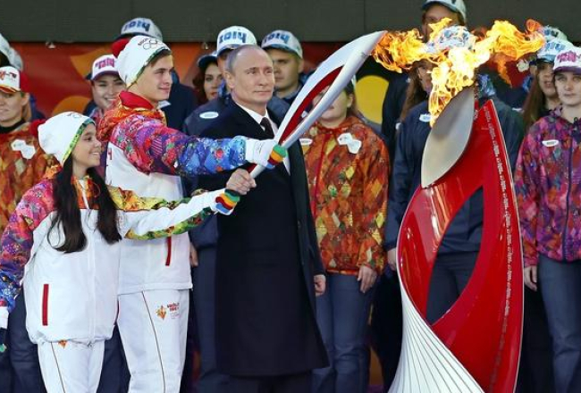 Krievijas prezidents Vladimirs Putins svinīgā ceremonijā iededzina olimpisko uguni. Foto: EPA/LETA
