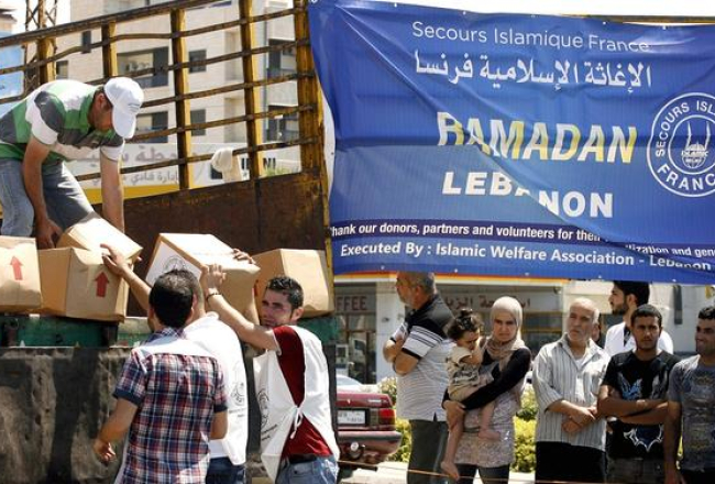 Sīrijas bēgļu nometnē piegādā palīdzību. Foto: AFP/LETA