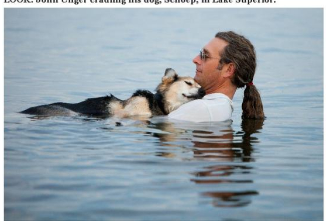 Džons Angers aijā savu iemigušo suni Šepu Superiora ezera ūdeņos Viskonsinā, ASV. Ekrāna stopkadrs. Foto no ''Huffington Post'', autore Hanna Stounhauza Hadsone, ''Stonehouse Photography''