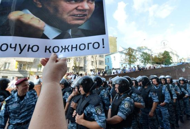 Ukraiņu opozīcija ar prezidenta Janukoviča portretu protestē pret krievu valodas lietojuma paplašināšanu. Foto: AFP/LETA