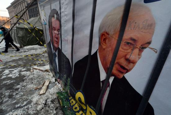 Bijušie - Ukrainas valdības vadītāja Mikolas Azarova (pa labi) un eksprezidenta Viktora Janukoviča portreti Maidana laikā šogad. Foto: AFP/LETA