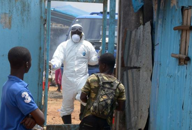 Ar Ebolas vīrusu infocēto radinieki gaida pie slimnīcas vārtiem Monrovijā. Foto: AFP/LETA