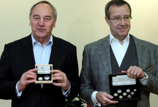 Igaunijas prezidents Tomass Hendriks Ilvess (pa labi) un Latvijas Valsts prezidents Andris Bērziņš apmainās ar naudas komplektiem. Foto no Prezidenta kancelejas