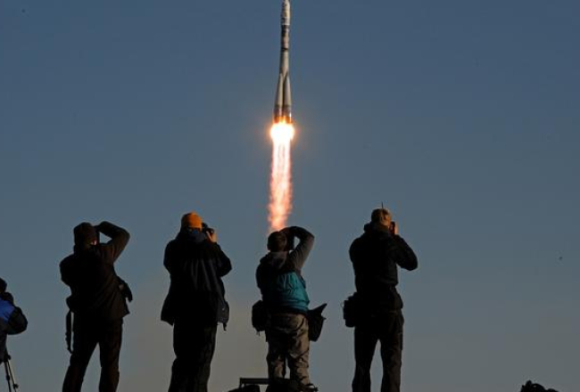 Krievijas kosmosa kuģa startu ar olimpisko lāpu fiksē fotogrāfi. Foto: AFP/LETA