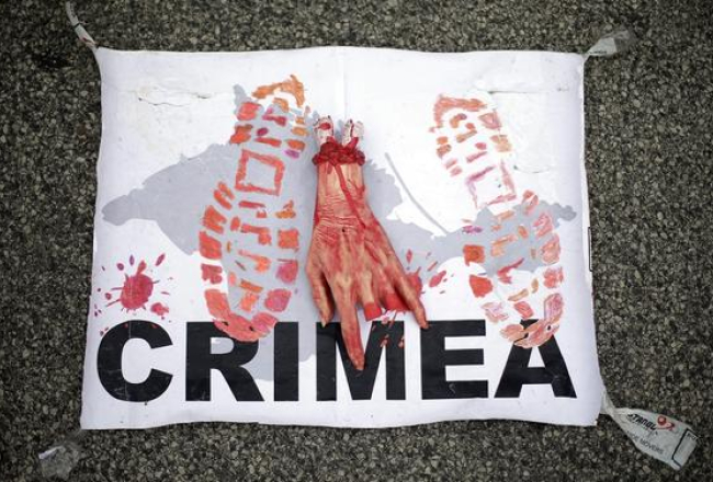 Protestētāju plakāts Vīnē 24.jūnijā, paužot prezidentam Putinam, kurš Vīnē ieradies oficiālā vizītē, nostāju pret Krievijas aneksiju Krimā. Foto: EPA/LETA