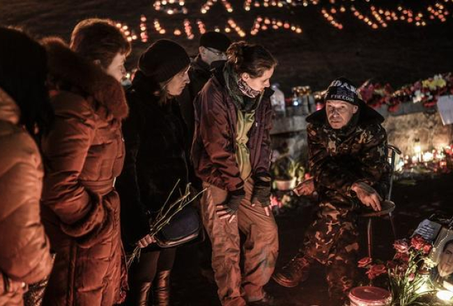 Cilvēki pagājušajā naktī joprojām pulcējās Maidanā, pieminot bojāgājušos. Foto: AFP/LETA