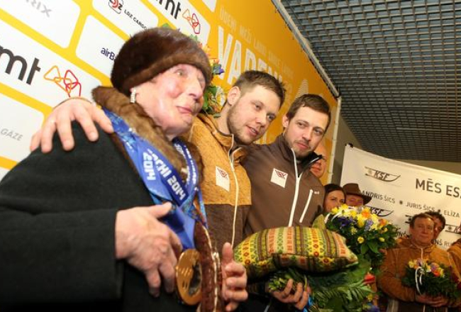 Vecmāmiņa Lilija Šica ar mazdēliem Soču olimpisko spēļu bronzas medaļu ieguvējiem - kamaniņu braucējiem Juri un Andri Šiciem svinīgās sagaidīšanas ceremonijas laikā lidostā "Rīga". Foto: Edijs Pālens, LETA