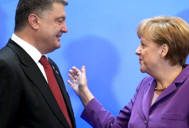 Vācijas kanclere Angela Merkele sveic Ukrainas prezidentu Petro Porošenko ar asociācijas līguma parakstīšanu. Foto: AFP/LETA