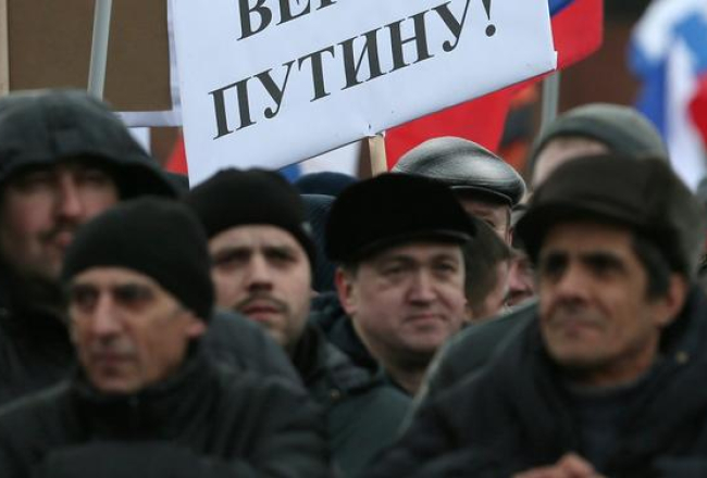 Tauta Maskavas Sarkanā laukumā, "svinot" Krimas aneksiju. Plakāts vēsta: "Ticam Putinam!" Foto: EPA/LETA