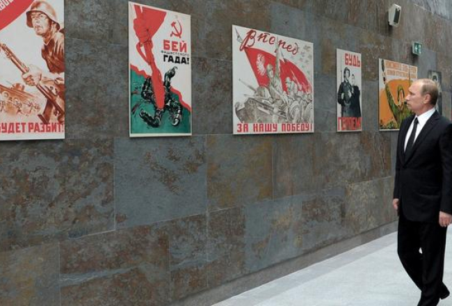 Krievijas prezidents Vladimirs Putins jūlijā apskata izstādi ar plakātiem no Otrā pasaules kara laika. Šo plakātu retoriku Krievija izmanto arī tagad savā propagandas karā, piemēram, uz plakāta, ko vēro Putins, rakstīts: "Sit fašistisko izdzimteni!". Foto: AFP/LETA