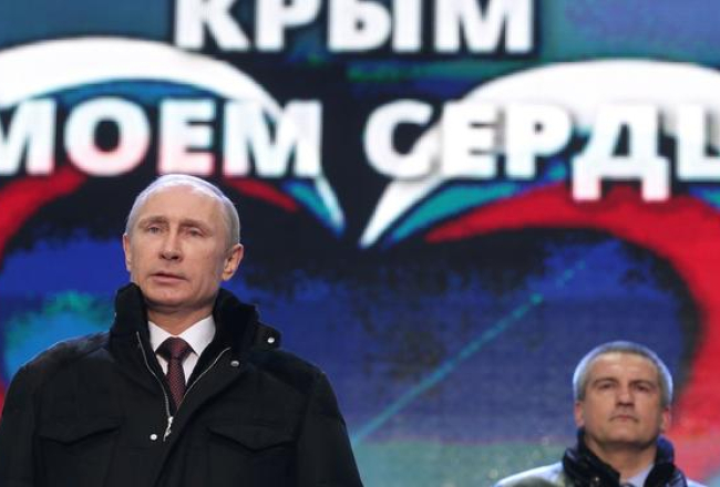 Vladimirs Putins (no kreisās) Krimas aneksijai veltītajā koncertā Sarkanajā laukumā Maskavā. Fonā - Krimas pašieceltais vadītājs Sergejs Aksenovs. Foto: ITAR-TASS/LETA