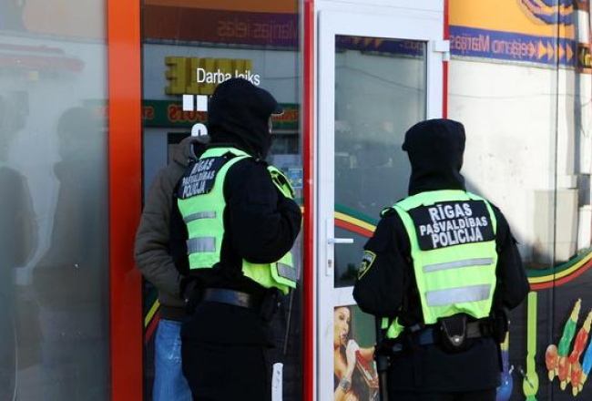Policijas darbinieki pie "legālo narkotiku" tirgotavas Marijas ielā. Foto: Edijs Pālens, LETA
