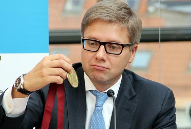 Rīgas mērs Nils Ušakovs pēta 'Nordea maratona' medaļu. Foto: Sintija Zandersone, LETA