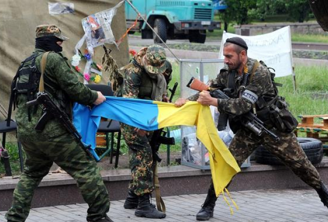 Prokrieviskie militāristi no vienības "Vostok" Doņeckā saplēš Ukrainas valsts karogu. Foto: AFP/LETA