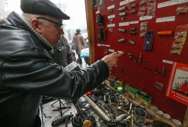 Kijevas centrā pēc nemieriem improvizēta izstāde, kurā redzami ieroči, kas izmantoti cīņās pret maidaniešiem. Foto: EPA/LETA