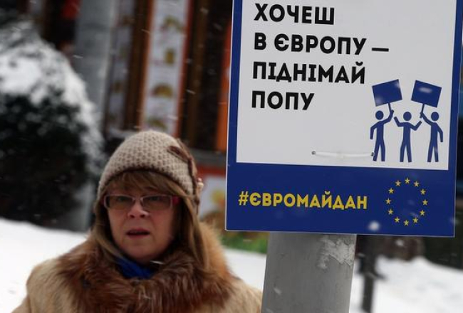 Protestētāja Kijevā, Neatkarības laukumā, aicina Eiropas atbalstītājiem būt aktīviem - "Gribi uz Eiropu - pecel pakaļu!". Foto: ITAR-TASS/LETA