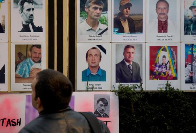 Ukrainas protestos bojāgājušo fotogrāfijas novietotas arī Londonā, godinot viņu piemiņu. Foto: AFP/LETA